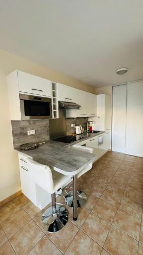 une cuisine avec des armoires blanches et un comptoir dans l'établissement Mari stunning apartment next to Monaco with a sea view terrace, à Beausoleil