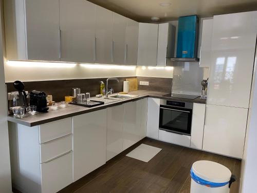 a kitchen with white cabinets and a stove top oven at Le Roofound - Porte de Paris - Métro à 5min - Entrée personnelle in Charenton-le-Pont