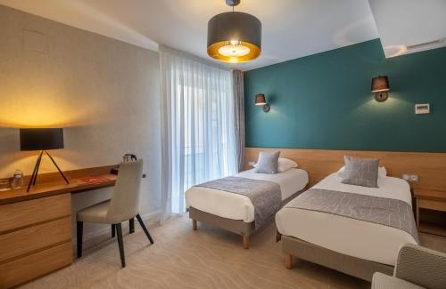 a hotel room with two beds and a desk and a desk at The Originals City, Hôtel Les Thermes de l'Avenue, Dax in Dax