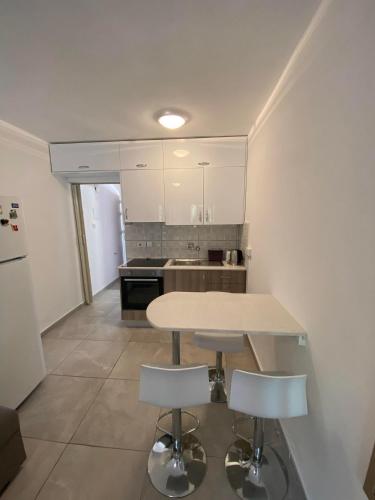 a kitchen with a table and two stools at Stay With Oleg C17 in Paralimni