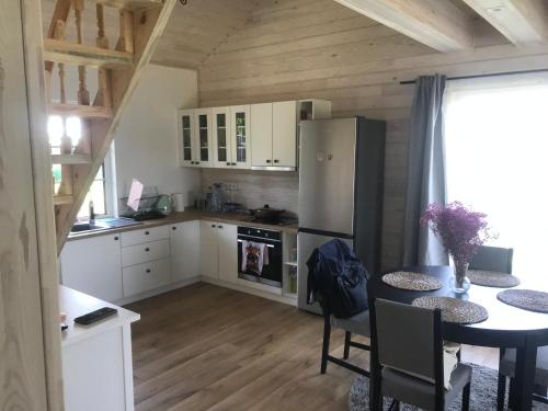 a kitchen with a table and a refrigerator at Cozy holiday house with sauna and entertainment in Puskelniai