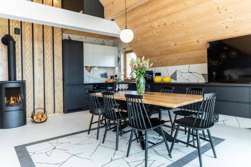 a kitchen and dining room with a wooden table and chairs at udanypobyt Apartamenty Czorsztyn Panorama 2 B in Czorsztyn
