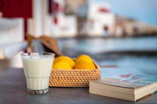 a glass of milk next to a basket of oranges at Magic Klima IV in Klima