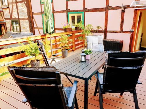 een houten tafel en stoelen op een terras met planten bij Ferienwohnung Goldstr.7 in Quedlinburg