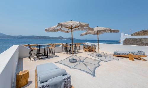 a patio with tables and chairs and umbrellas at Magic Klima IV in Klima