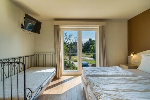 1 dormitorio con 2 camas y ventana grande en Logie Bloemenlust en Wetteren