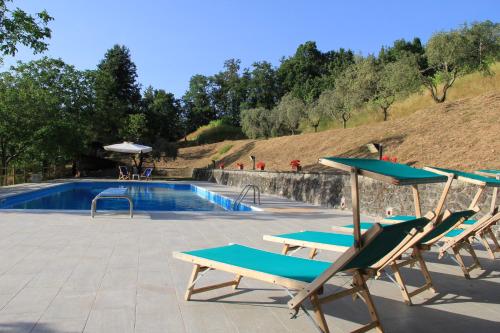 a group of chairs and a swimming pool at Villa Veralda, la magia di una Toscana insolita in Fivizzano