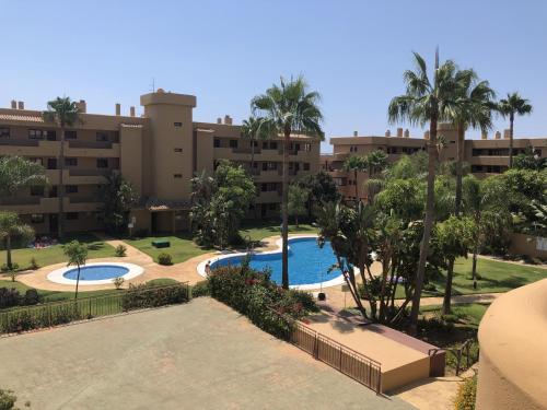 an apartment complex with a swimming pool and palm trees at La Cala Azul 2 bedroom apartment with big sunny terrace & walking distance to all the amenities - costa del sol in La Cala de Mijas