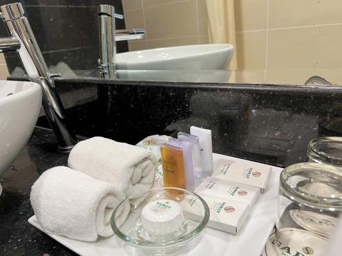 a bathroom counter with towels and products on it at Sapaly Lao Cai City Hotel in Lao Cai