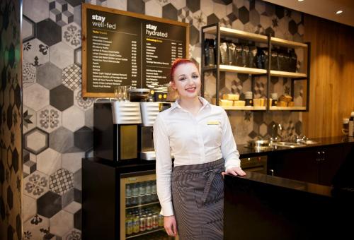 a woman standing in front of a counter in a kitchen at Staycity Aparthotels Birmingham Central Newhall Square in Birmingham