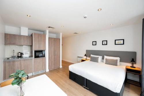 a bedroom with a large bed and a kitchen at Staycity Aparthotels Birmingham Jewellery Quarter in Birmingham