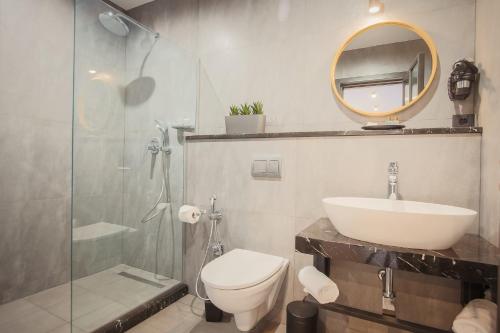 a bathroom with a sink and a toilet and a mirror at Hotel Tuta in Tbilisi City