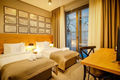Cette chambre comprend deux lits et un bureau. dans l'établissement Hotel Tuta, à Tbilissi