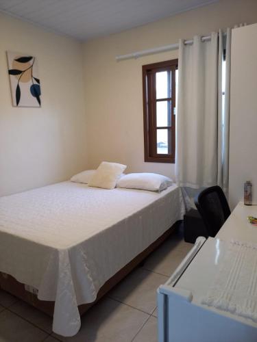 Un dormitorio con una cama grande y una ventana en Recanto Sete Mares Hospedagem Familiar, en Balneário Camboriú