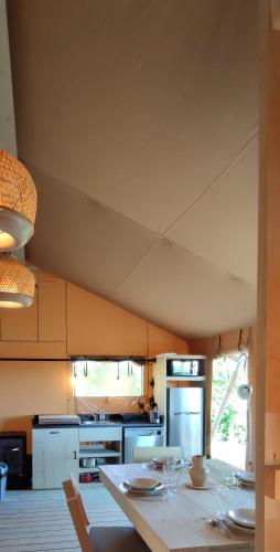 une cuisine avec une table avec des verres à vin dessus dans l'établissement Tente Hula, à Colleville