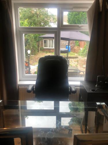 a black chair sitting in front of a window at Strand Beach View House in Gillingham