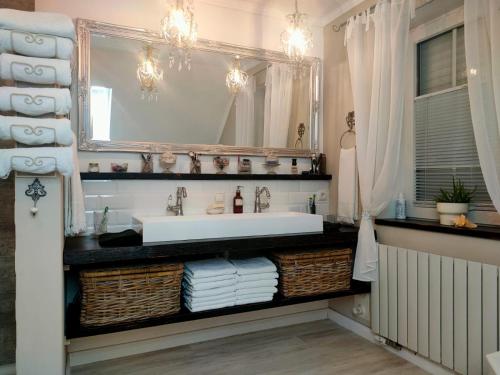 a bathroom with a sink and a mirror at Luana`s White Cottage in Surwold