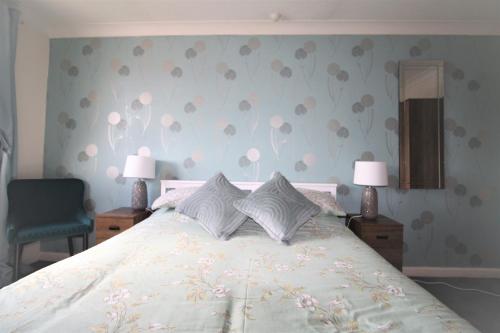 a bedroom with a large bed with two lamps at 3 Bed Semi - Sleeps 5 - Private Garden & Parking - Quiet Cul De Sac Location - Dog Friendly - Fast Wifi - Close to Motorway Access in Doncaster