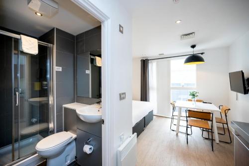 a bathroom with a sink and a toilet and a table at Staycity Aparthotels Birmingham Jewellery Quarter in Birmingham