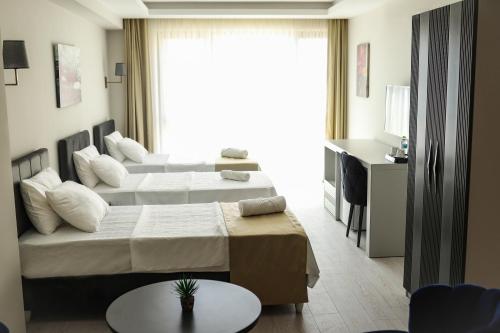 Habitación de hotel con 2 camas y mesa en PETRA HOTEL TUZLA, en Tuzla