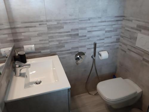 uma casa de banho com um WC branco e um lavatório. em IL NIDO DELLA FENICE em Brunate