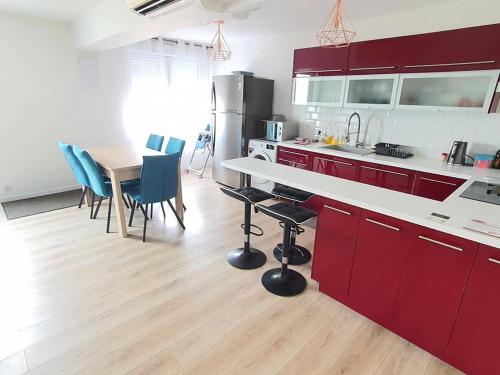 a kitchen with red cabinets and a table and chairs at Gîte 5 personnes Dompierre sur Besbre in Dompierre-sur-Besbre