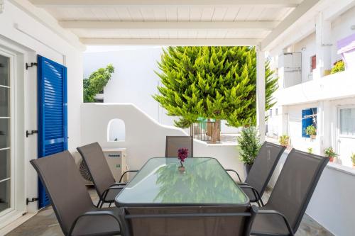 une salle à manger avec une table et des chaises en verre dans l'établissement Parian Charming 3bedroom Home, à Parikia