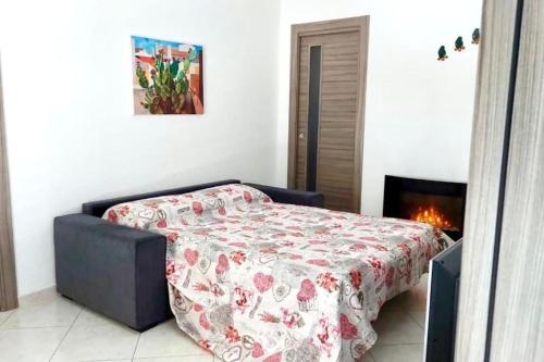 Un dormitorio con una cama con una manta. en Casetta del Maestro, en Raffadali