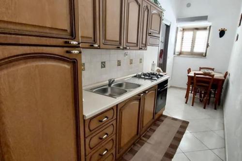 Raffadali的住宿－Casetta del Maestro，厨房配有水槽和炉灶 顶部烤箱
