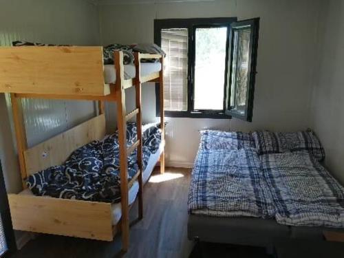 1 dormitorio con 2 literas y 1 cama en Obytný kontejner BUNGALOV en Senorady