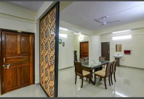 una sala da pranzo con tavolo, sedie e porta di Andaman Castle a Port Blair