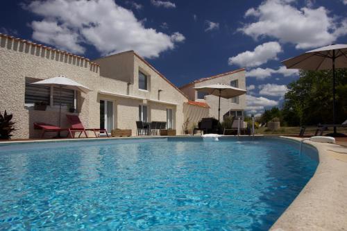 a swimming pool in front of a house at La Charentine in Échillais