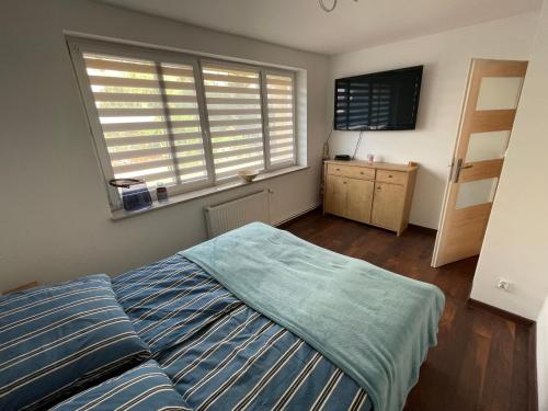 um quarto com uma cama e uma grande janela em Apartament przy uzdrowisku. em Kamień Pomorski