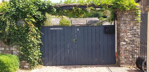 a blue gate in a brick wall with an entrance at Monkton Court House B&B in Honiton
