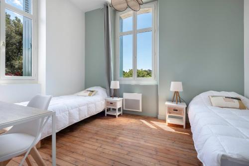 a bedroom with two beds and two windows at Bel appartement vue sur le port du Croisic in Le Croisic