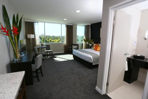 a hotel room with a bed and a table at Springfield Lakes Boutique Hotel in Springfield Lakes
