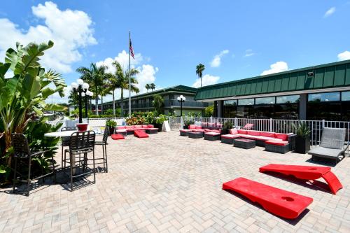 a patio with red benches and tables in front of a building at Remodeled, Huge Pool, Tiki Bar & Grill, Quiet Room in Sarasota