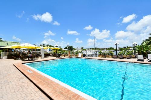 a swimming pool at a hotel with chairs and umbrellas at Remodeled, Huge Pool, Tiki Bar & Grill, Quiet Room in Sarasota