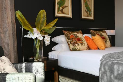 a bedroom with two beds and a vase of flowers at Springfield Lakes Boutique Hotel in Springfield Lakes