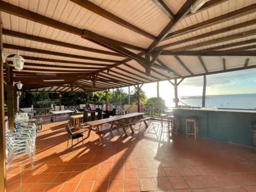 a pavilion with tables and chairs on a patio at Le Nid Tropical in Bouillante