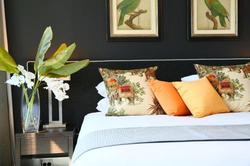 a bedroom with a white bed with colorful pillows at Springfield Lakes Boutique Hotel in Springfield Lakes
