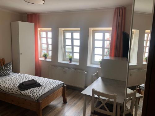 a room with a table and a table and windows at Altstadt Pension Herborn in Herborn