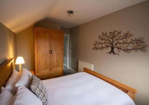 a bedroom with a bed with a tree on the wall at Modern Apartment Sherburn In Elmet in Sherburn in Elmet