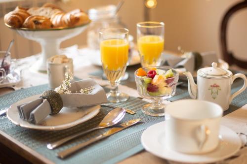 a table with a breakfast of coffee and orange juice at Chambre d'Hôtes La Courbe in Lugan