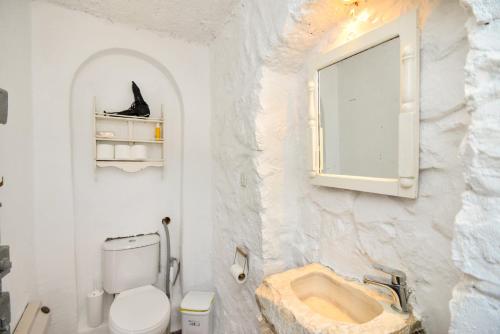 a white bathroom with a sink and a toilet at Hydra town, Relaxing patio Panoramic sea view in Hydra