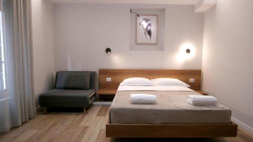 um quarto com uma cama e uma cadeira em KONI's Studio Apartments em Tirana
