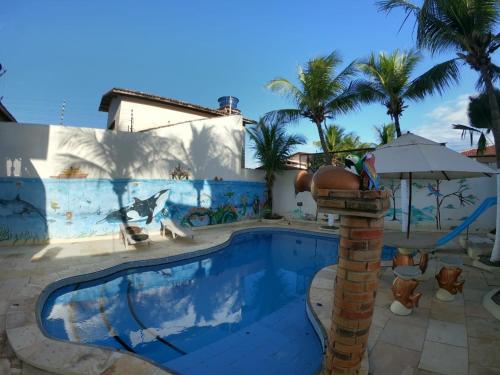 a pool at a resort with a painting on the wall at Canoa Suites & Apartments in Canoa Quebrada