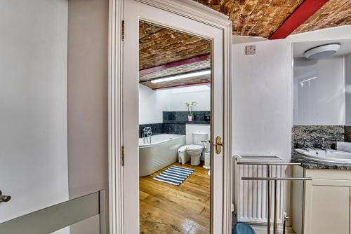 a bathroom with a tub and a sink at Guest Homes - The Basement On The Tything in Worcester