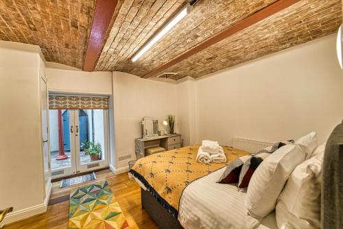a bedroom with a bed and a brick ceiling at Guest Homes - The Basement On The Tything in Worcester
