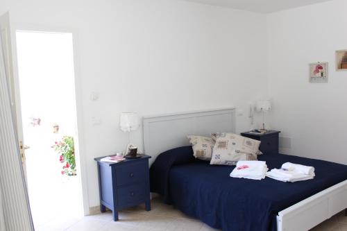 una camera da letto con letto con lenzuola e cuscini blu di Book and Bed a Maglie